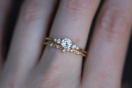 Moissanite with round diamond side stones, five stone ring