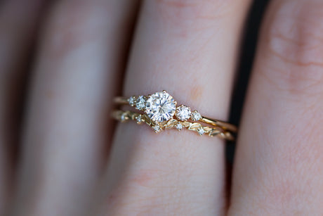 Moissanite with round diamond side stones, five stone ring